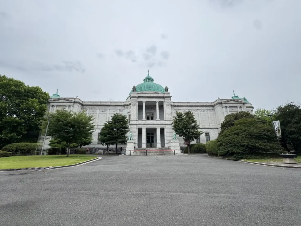 Wide view of the historic stone Hyokeikan building with green domed roofs at the Tokyo National Museum.