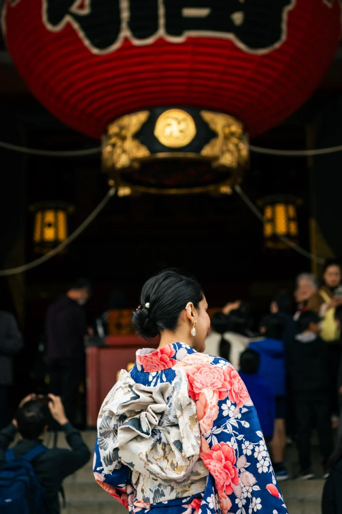Woman wearing a traditional floral kimono in front of the giant red lantern at Sensoji Temple in Asakusa, Tokyo.