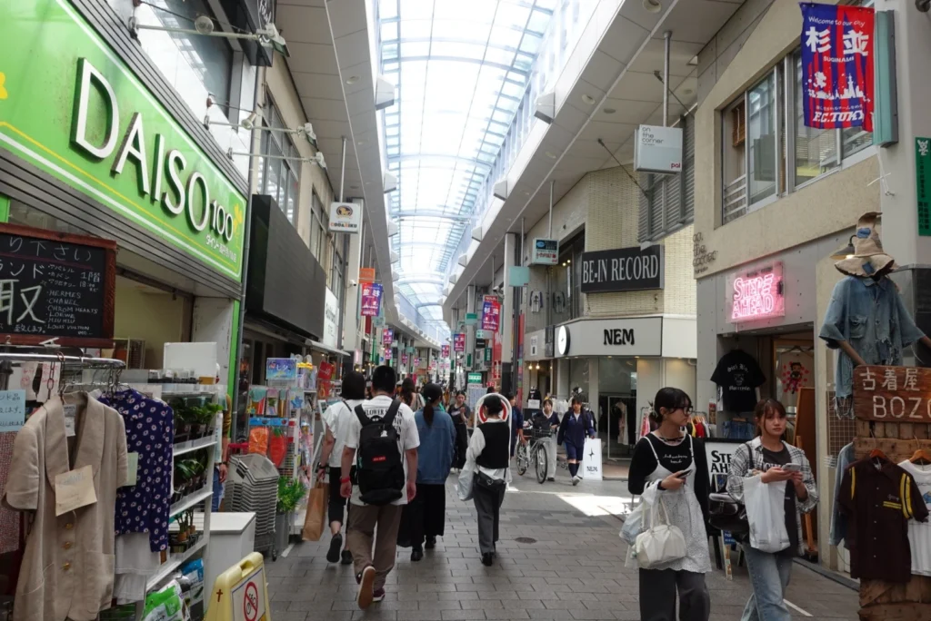 Bustling covered walkway of the Pal Shotengai shopping street in Koenji, featuring a large glass skylight and lined with local shops and Koenji vintage stores.
